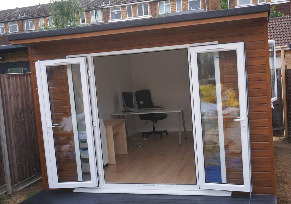 Open French doors showing the furnished garden office