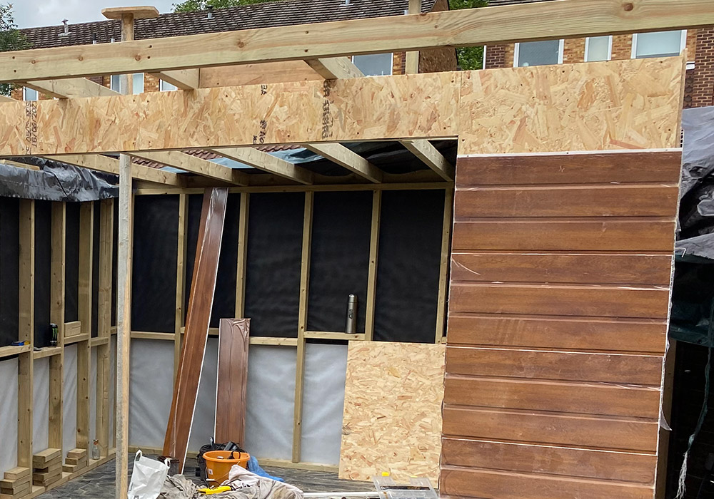 External timber cladding being fitted around a framed opening