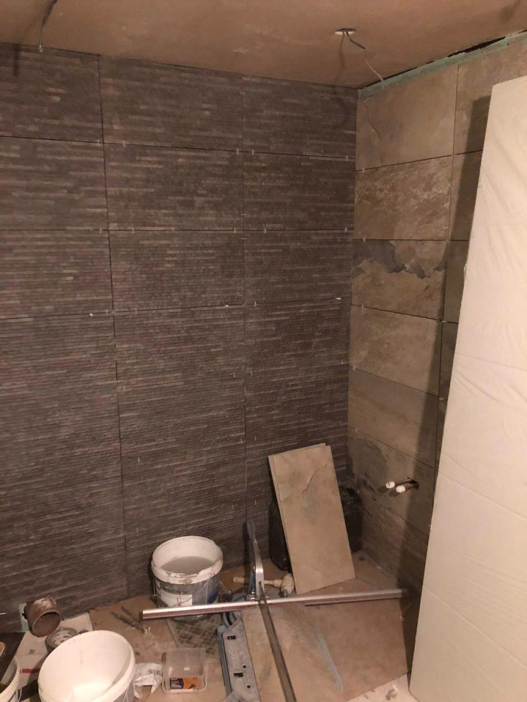 Bathroom wall tiling and recessed shelf during installation