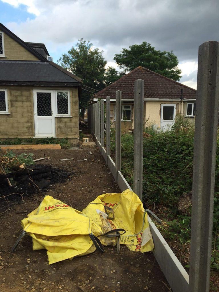 Exterior preparation beside the house, with fencing and construction materials