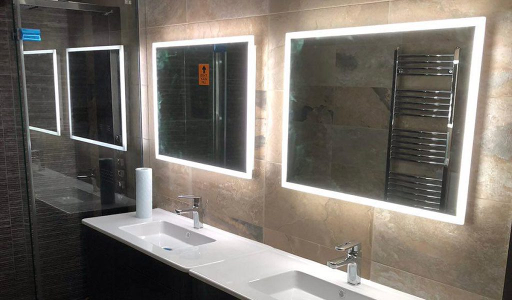Completed bathroom double vanity with illuminated mirrors